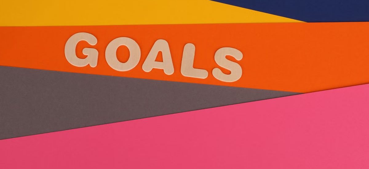 Vibrant abstract image with the word 'Goals' on multi-colored paper background.