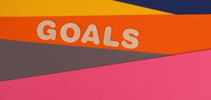 Vibrant abstract image with the word 'Goals' on multi-colored paper background.