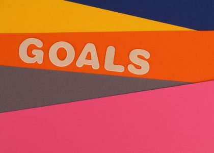 Vibrant abstract image with the word 'Goals' on multi-colored paper background.