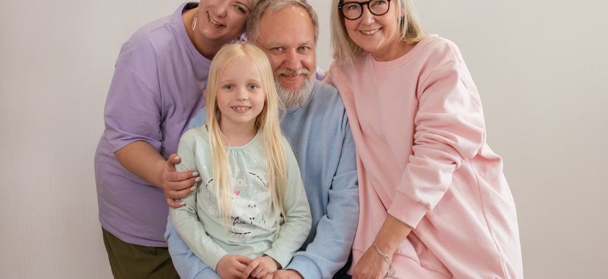 A happy multigenerational family posing indoors with smiles and affection.