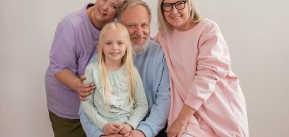 A happy multigenerational family posing indoors with smiles and affection.