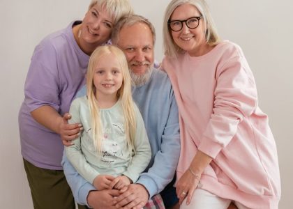 A happy multigenerational family posing indoors with smiles and affection.